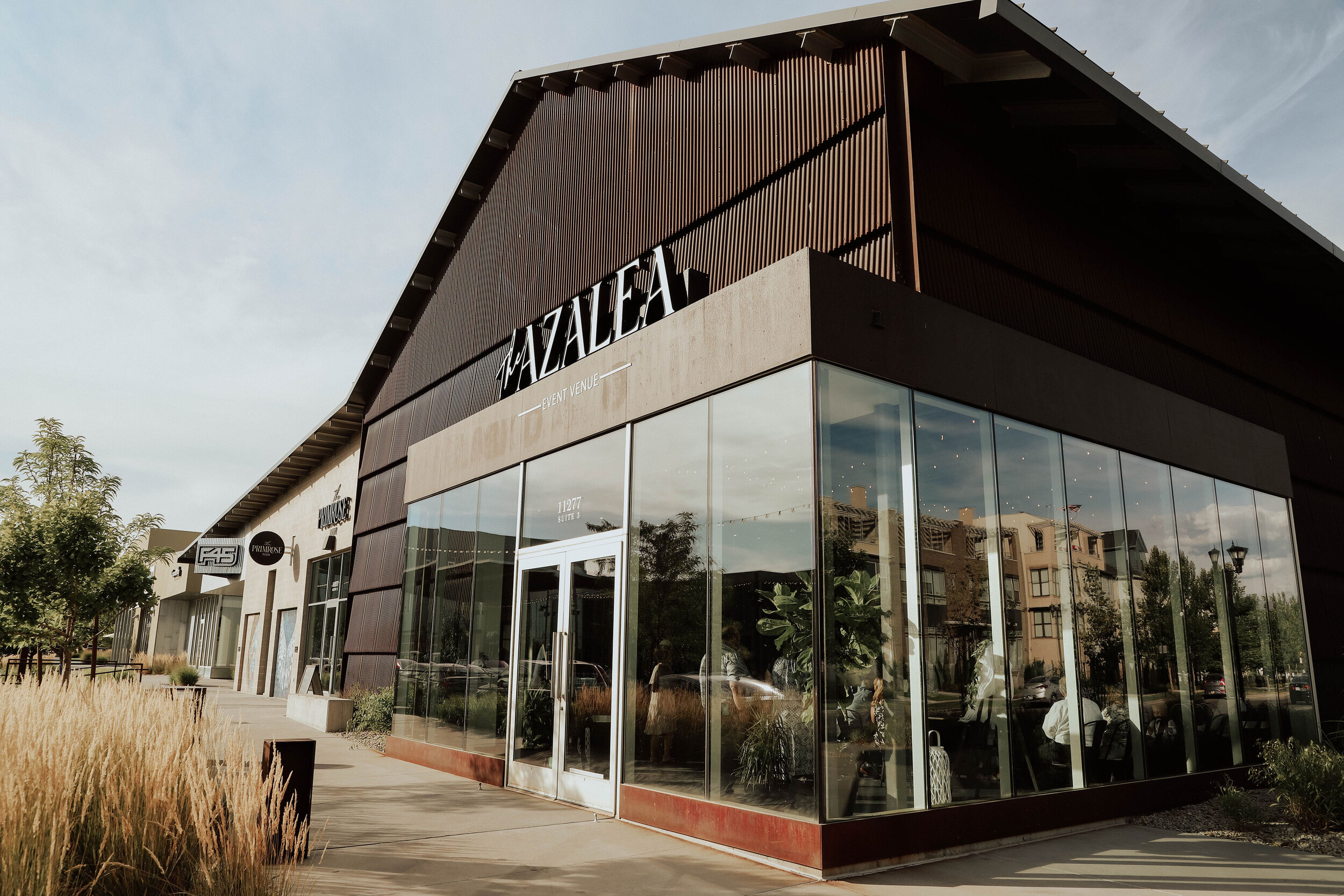 The Azalea Event Venue - Modern venue with tall ceilings, brick accent wall and big windows in SoDa Row